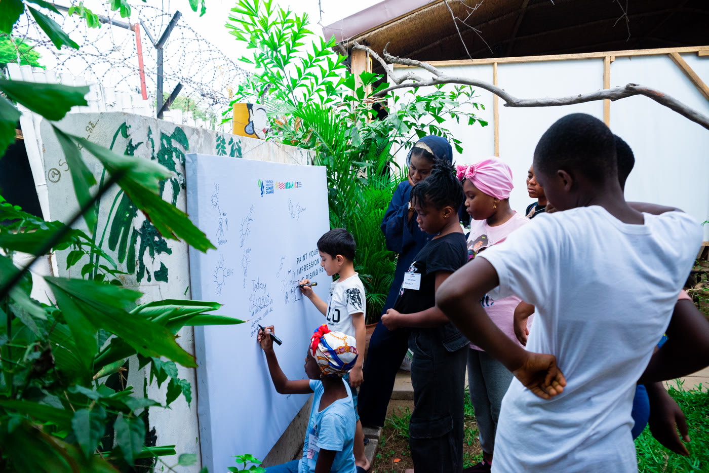 Young people mapping and sketching local climate solutions on design boards during a CCAIE workshop