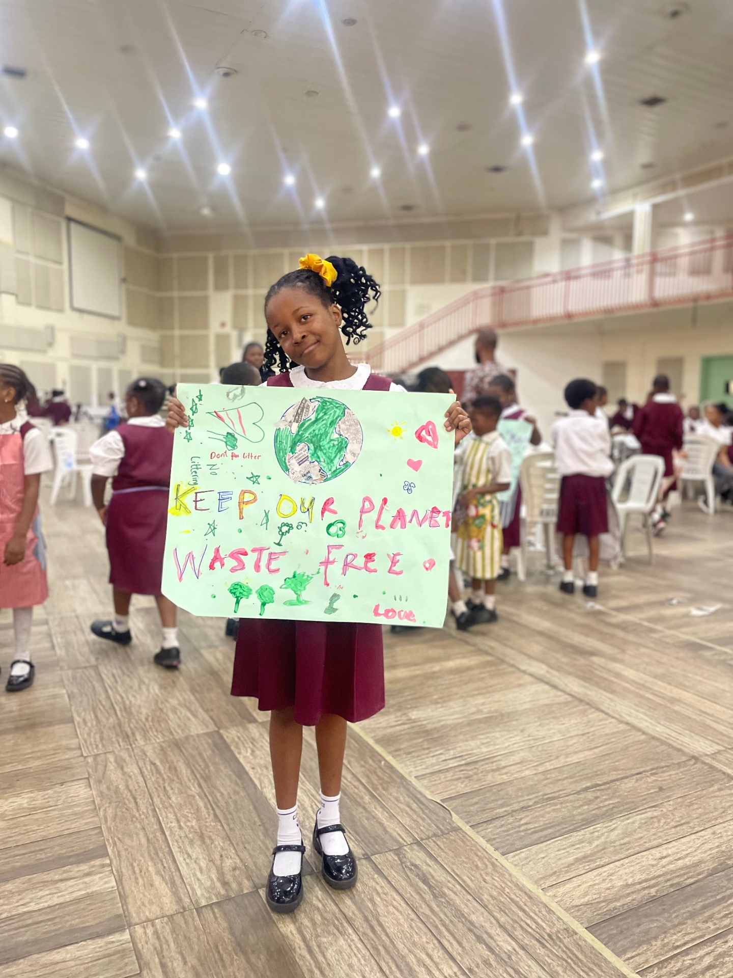A child holding a hand-drawn climate poster during a CCAIE activity
